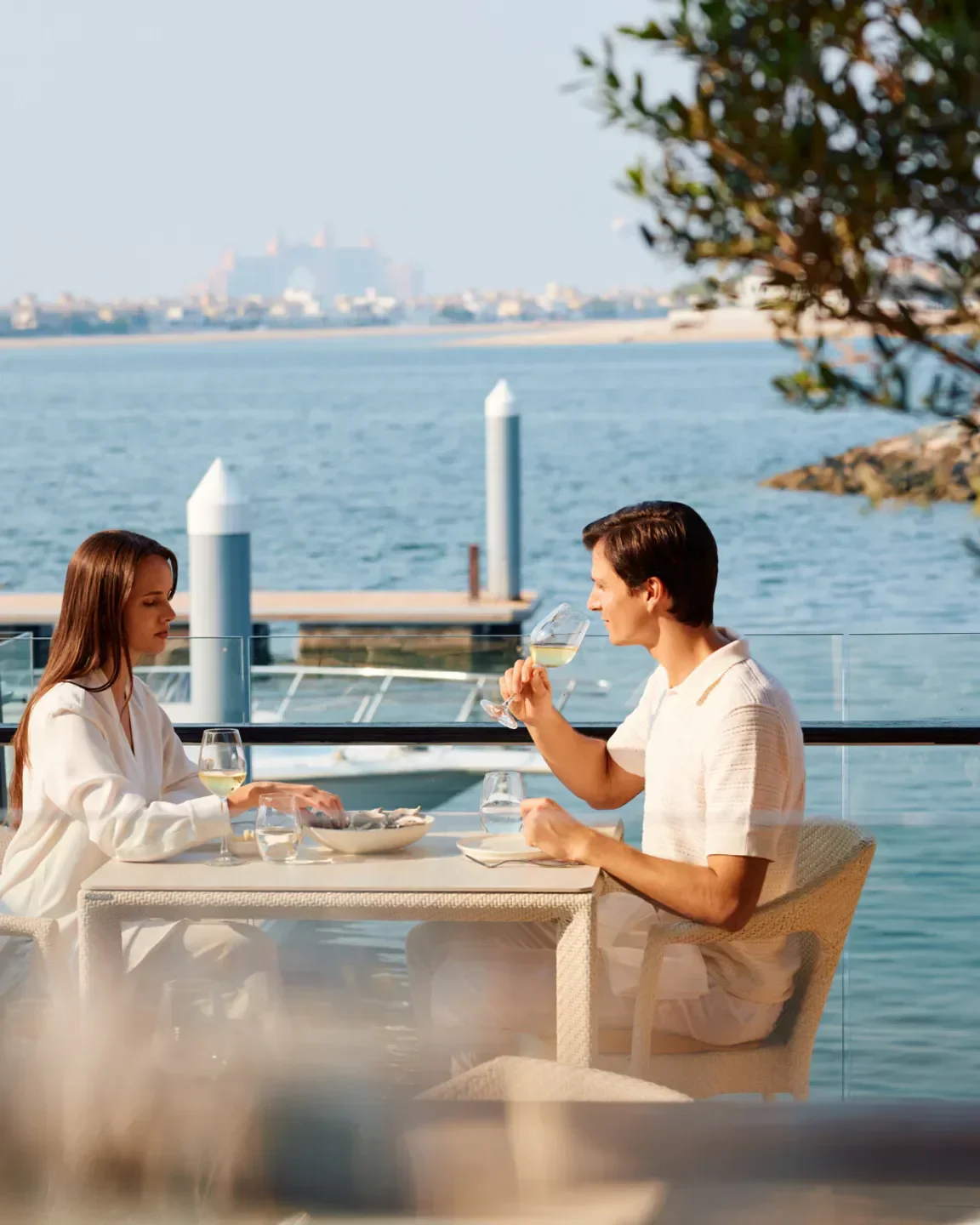 Couple enjoying drinks at 101 Dining Lounge and Marina in Dubai with water view.