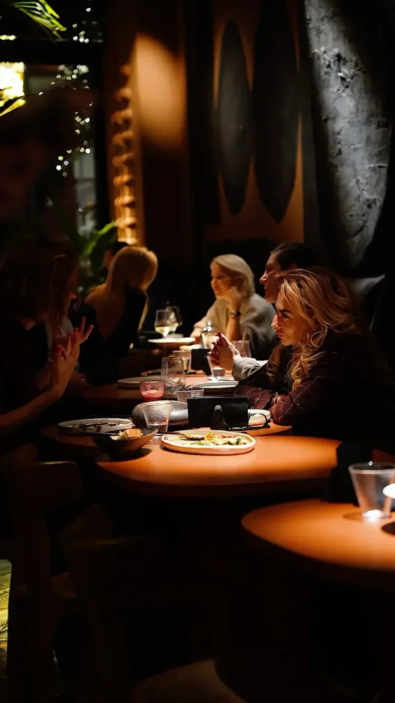 Cozy dining scene at 11 Woodfire in Dubai, showcasing intimate conversations and delicious food.