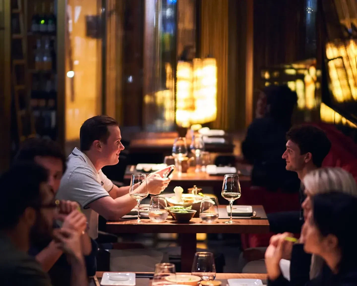 Dining at 99 Sushi Dubai, people enjoying their meals at a stylish restaurant.