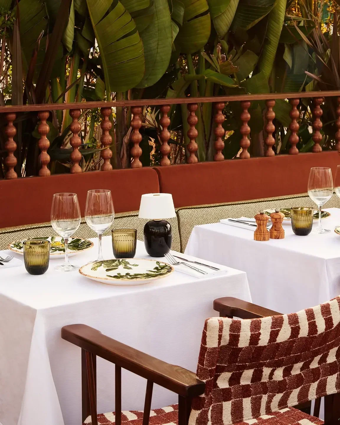 Dining table setting at Africa Queen restaurant in Dubai, with elegant glassware and lush greenery.