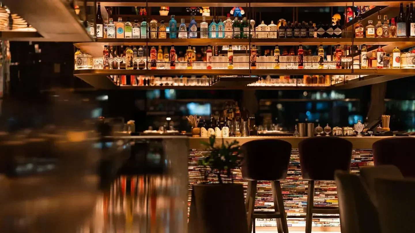 Interior of Clap Dubai rooftop bar with stylish decor and spirits display.