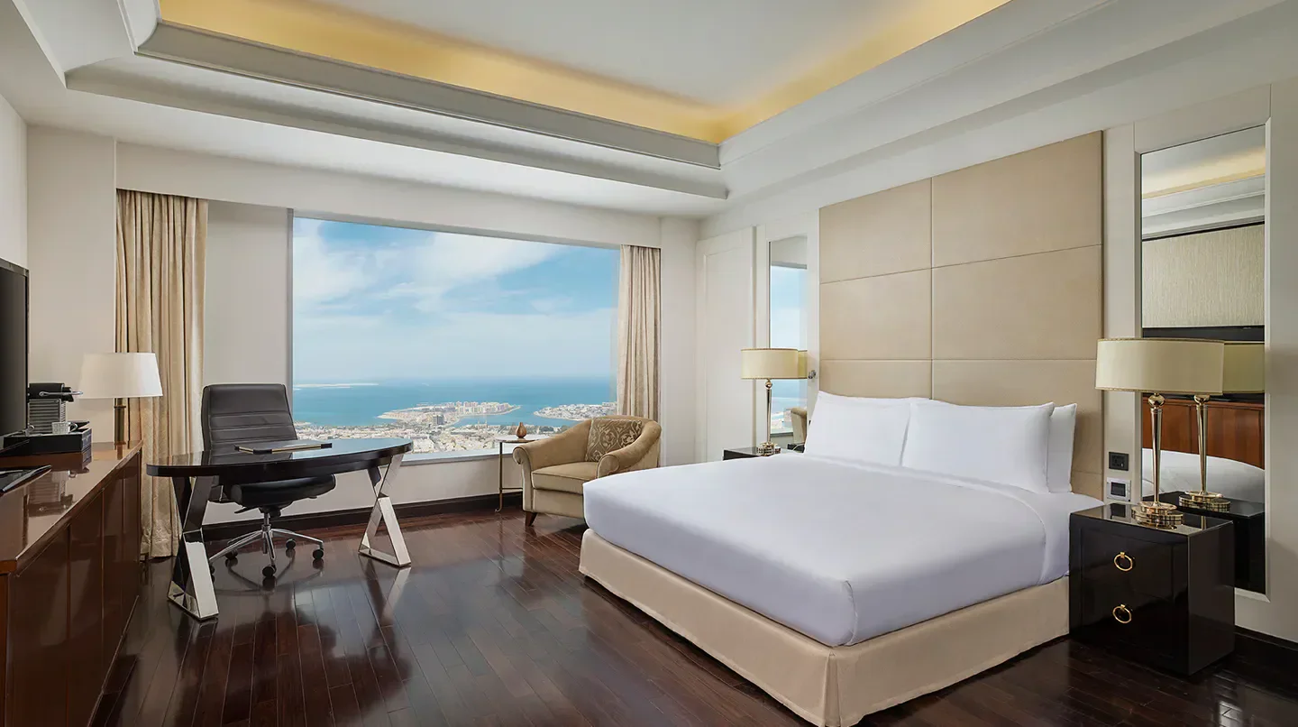 Spacious hotel room with ocean view at Conrad Dubai, overlooking Dubai skyline.