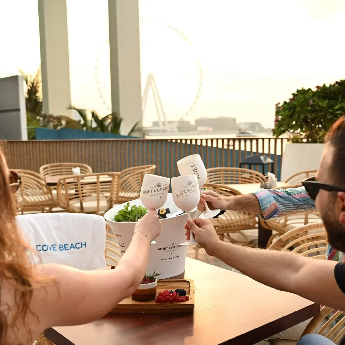 Cheers at Cove Beach Dubai with champagne glasses, overlooking the city view