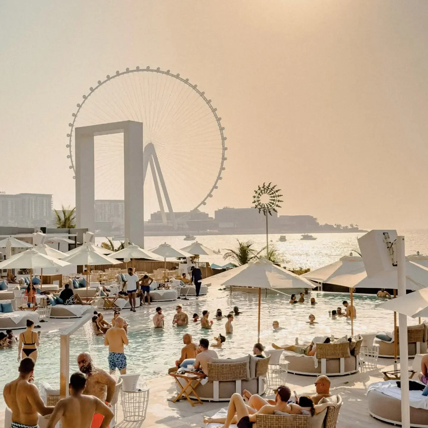 Cove Beach Dubai: People enjoying pool with the Ain Dubai Ferris wheel in the background