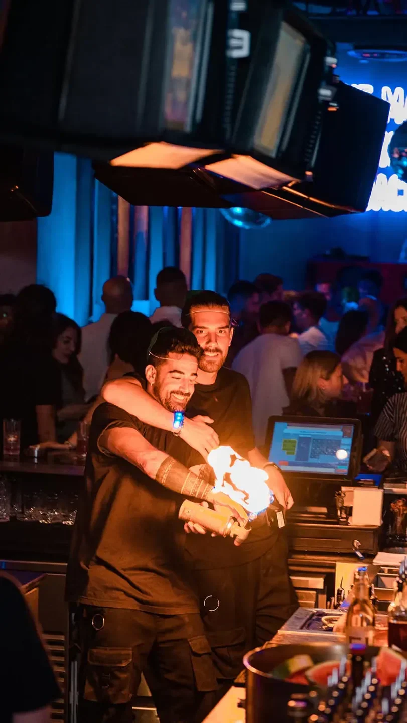Ergo Dubai bartender lights up cocktail with flames, celebrating the night.