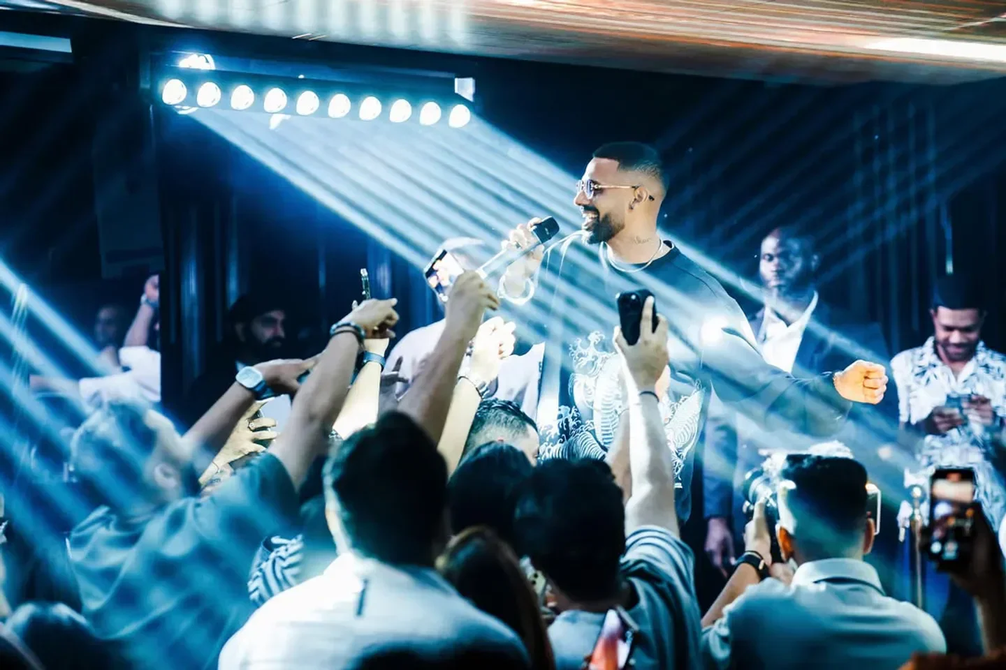 Energetic crowd at Icy nightclub in Dubai, illuminated by spotlights during a performance.