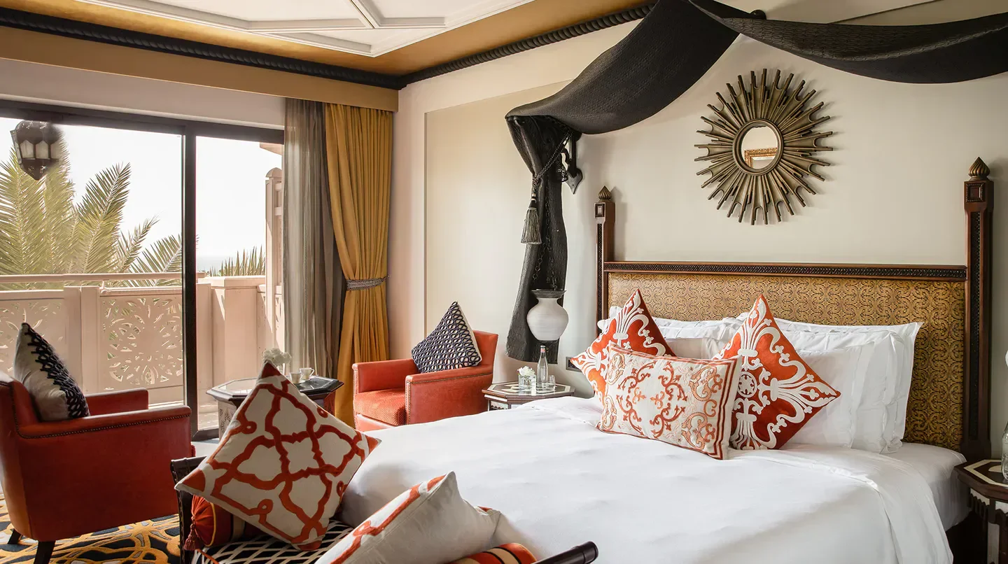 Luxury bedroom at Jumeirah Al Qasr in Dubai with balcony and stylish decor.