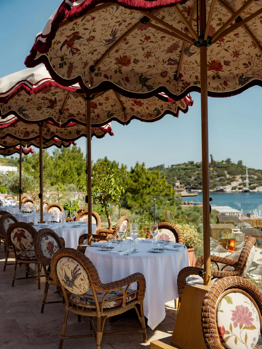 Maison Revka beach club in the city offering elegant outdoor dining with floral umbrellas and sea views