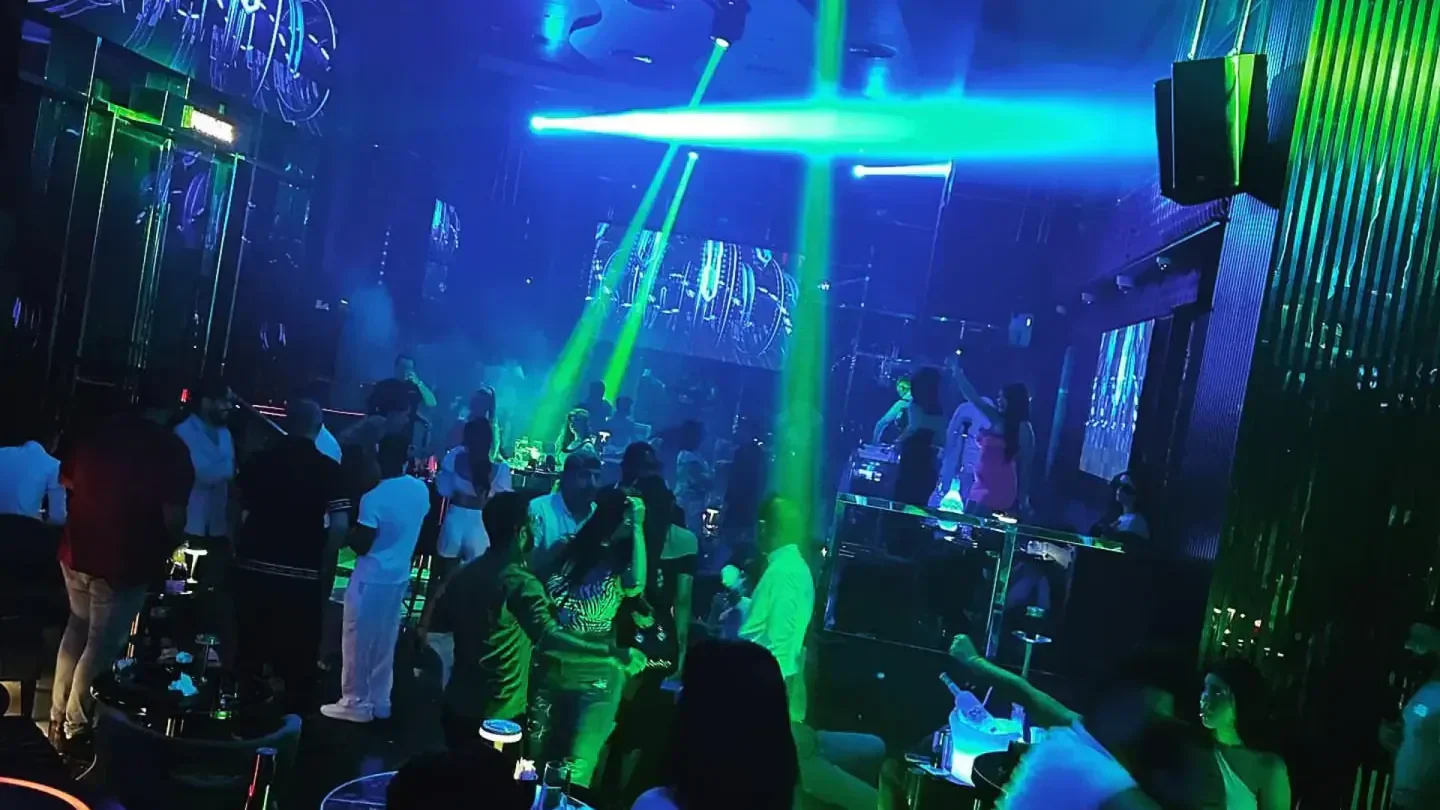 Inside Marbaiya nightclub in Dubai with people dancing under neon lights.