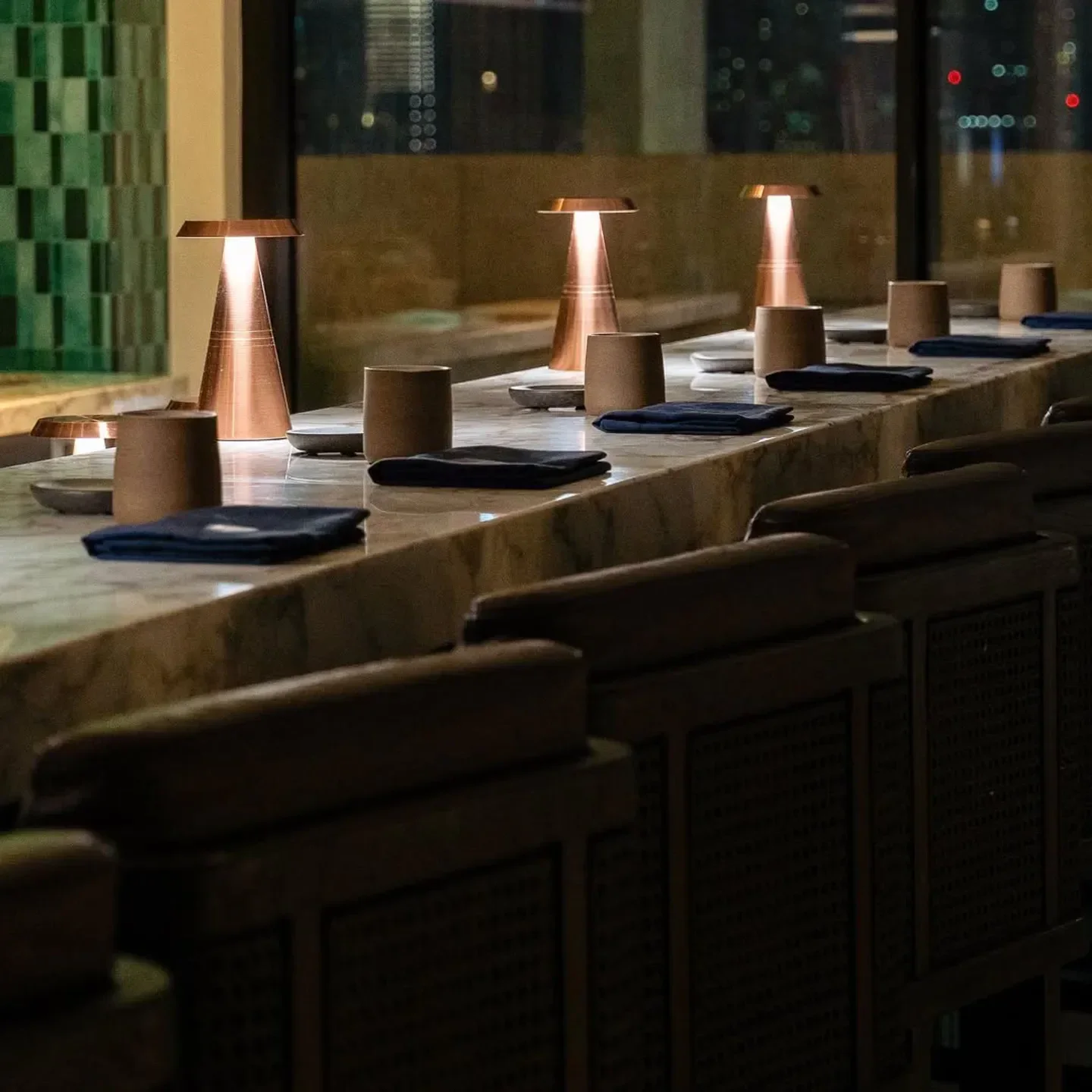 Elegant dining at Moonrise Dubai restaurant, showcasing stylish copper lamps and seating.