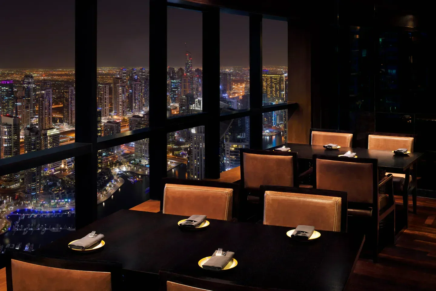 Dining tables at Observatory Bar & Grill Dubai, with stunning city views at night.