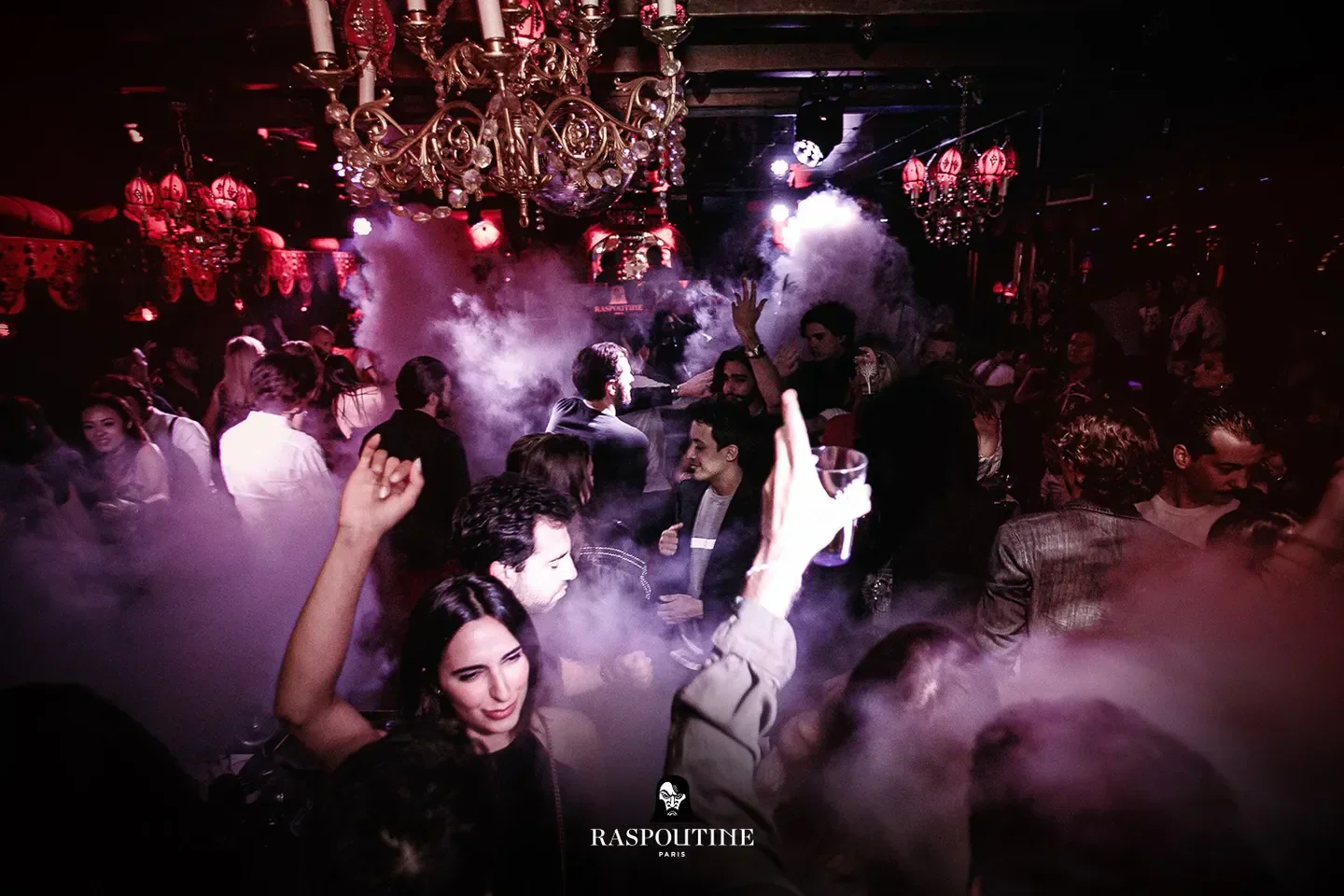 Energetic party scene at RASPOUTINE nightclub in Dubai, with chandeliers and atmosphere.