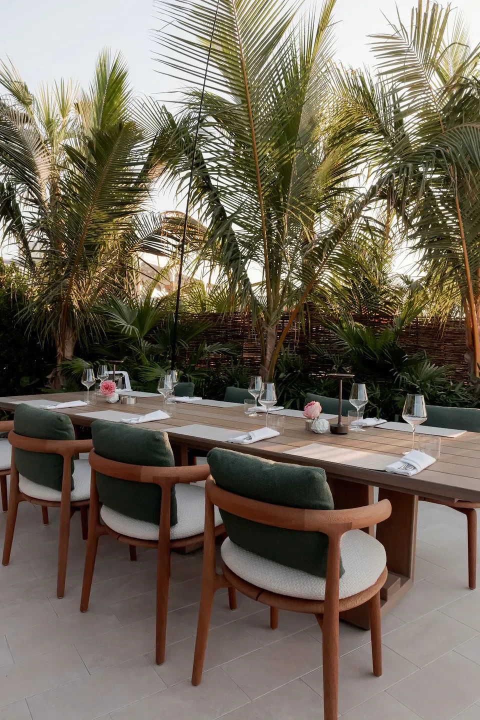 Sakhalin Dubai restaurant's outdoor dining with lush palm trees and elegant table setting.
