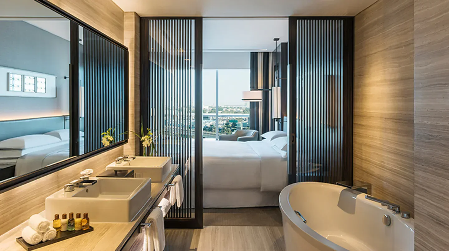 Luxury bathroom and bedroom suite at the Sheraton Grand Hotel, Dubai, with city view