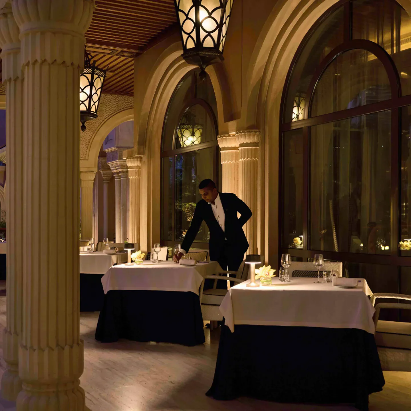 Elegant dining room at Stay by Yannick Alléno in Dubai, served by a waiter.