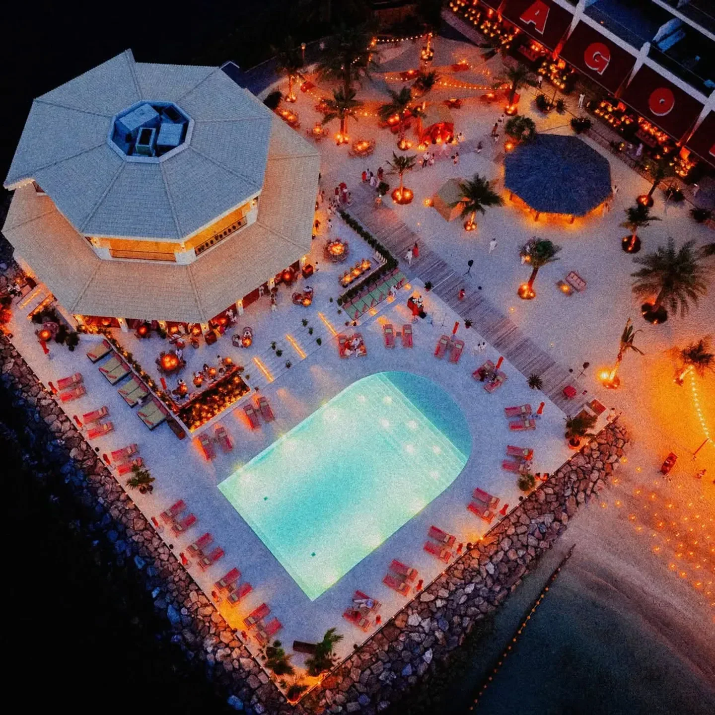 Aerial view of Tagomago Beach Club in Dubai with pool and evening ambiance