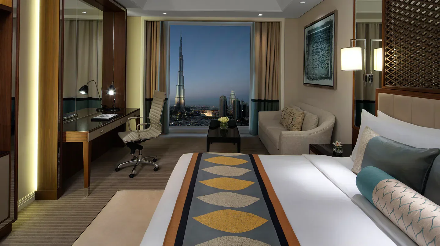 Luxury room at Taj Dubai with views of the Dubai skyline at dusk.