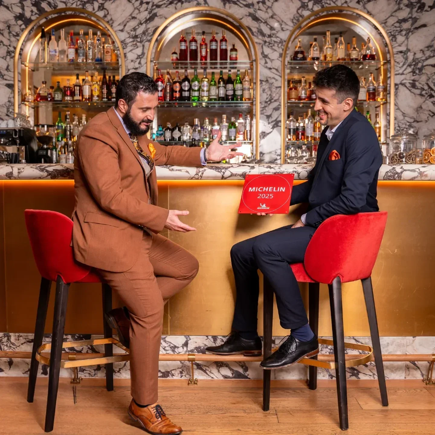 Two men at The Artisan by Enoteca Pinchiorri in Dubai, celebrating with Michelin award.