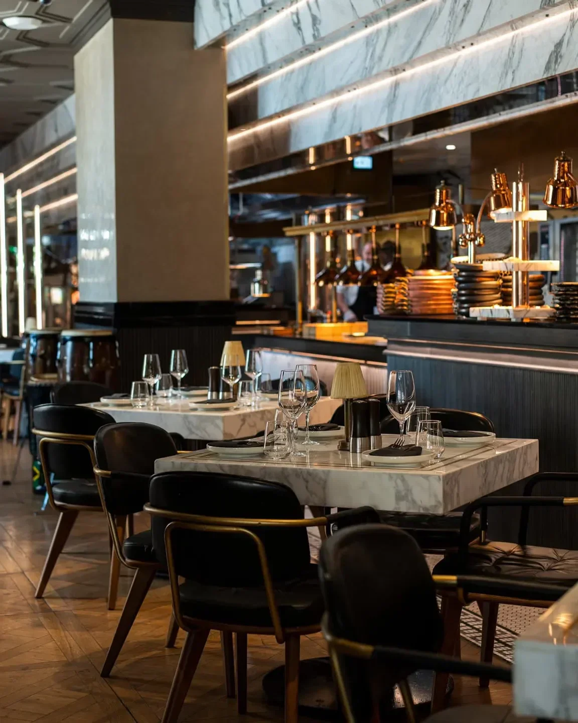 Elegant dining space at The Meat Co restaurant in Dubai with marble tables and stylish chairs.