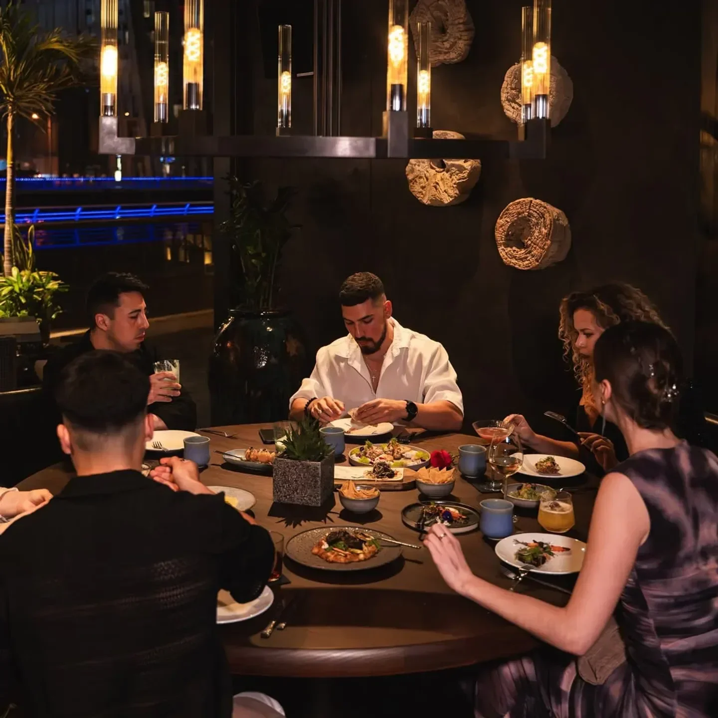 Group dining at Toro Toro Dubai restaurant, enjoying food and cocktails together.