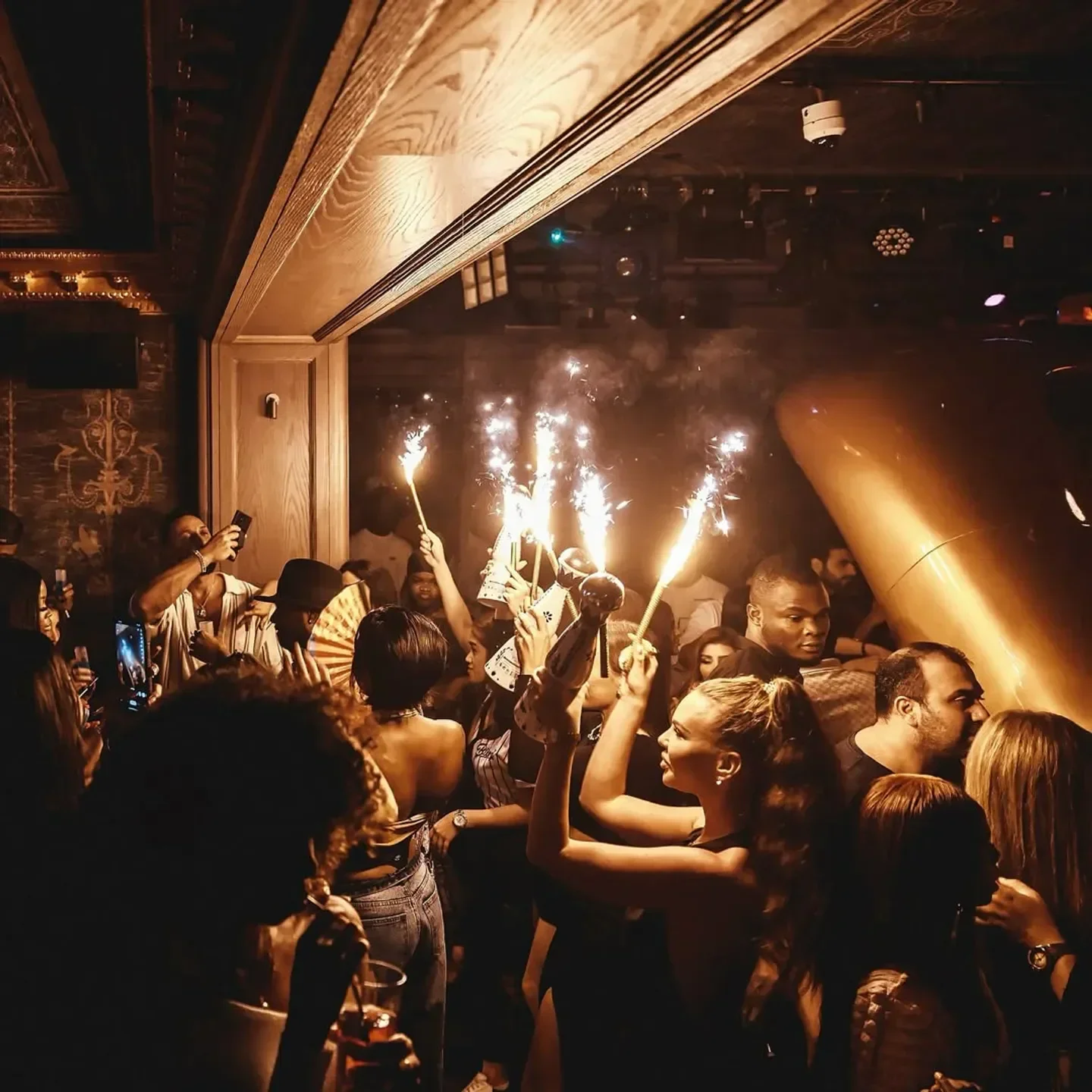 Sparklers light up the crowd at Toy Room Dubai, a lively nightclub scene.