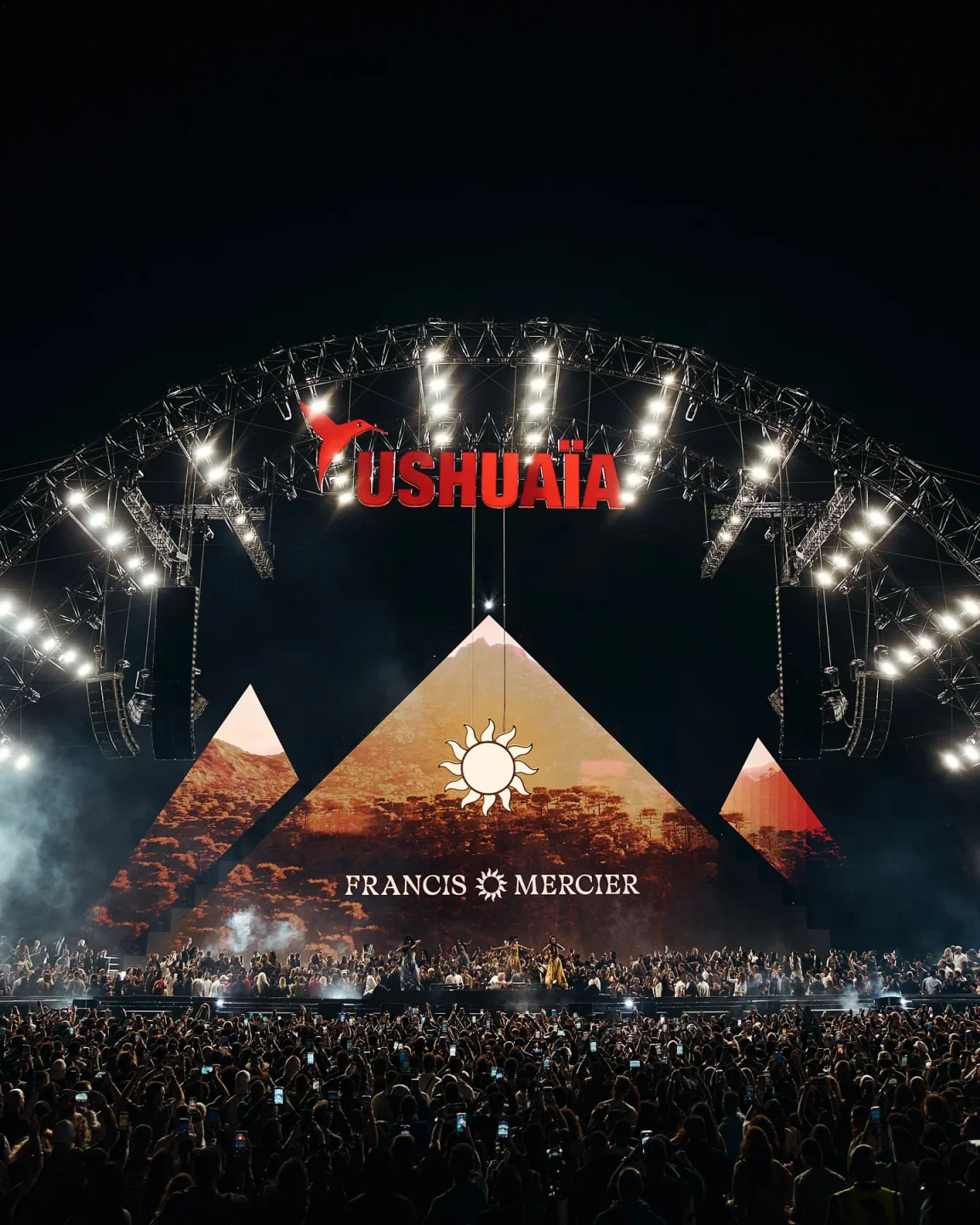 Ushuaia nightclub stage with "FRANCIS MERCIER" and sun graphic, crowd cheers in the city